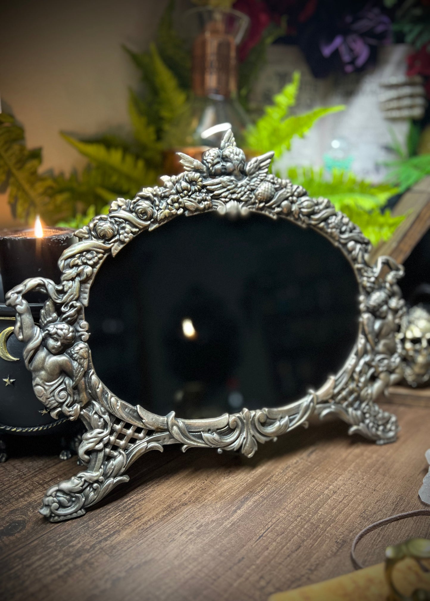 Large heirloom antique divination black scrying mirror with ornate metal frame with cherubs and angels