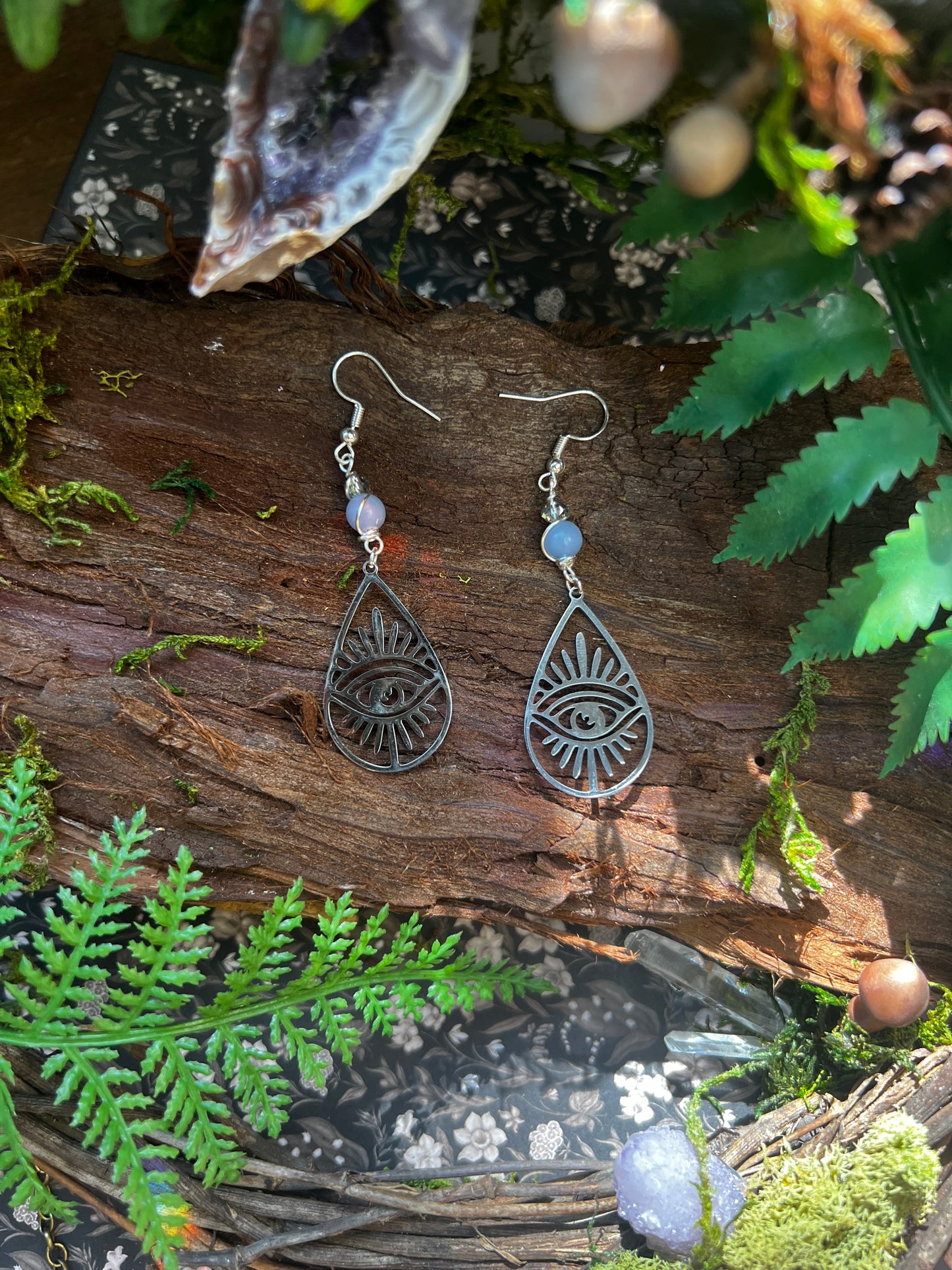 Close-up of celestial earrings featuring angelite and spiritual protection motifs