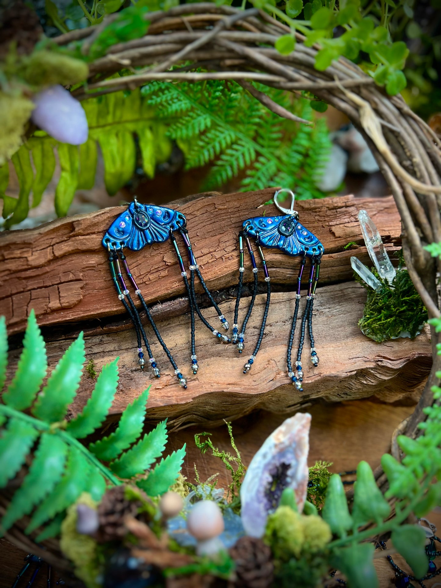 Hand-sculpted blue moth earrings with mystical crystal centerpiece