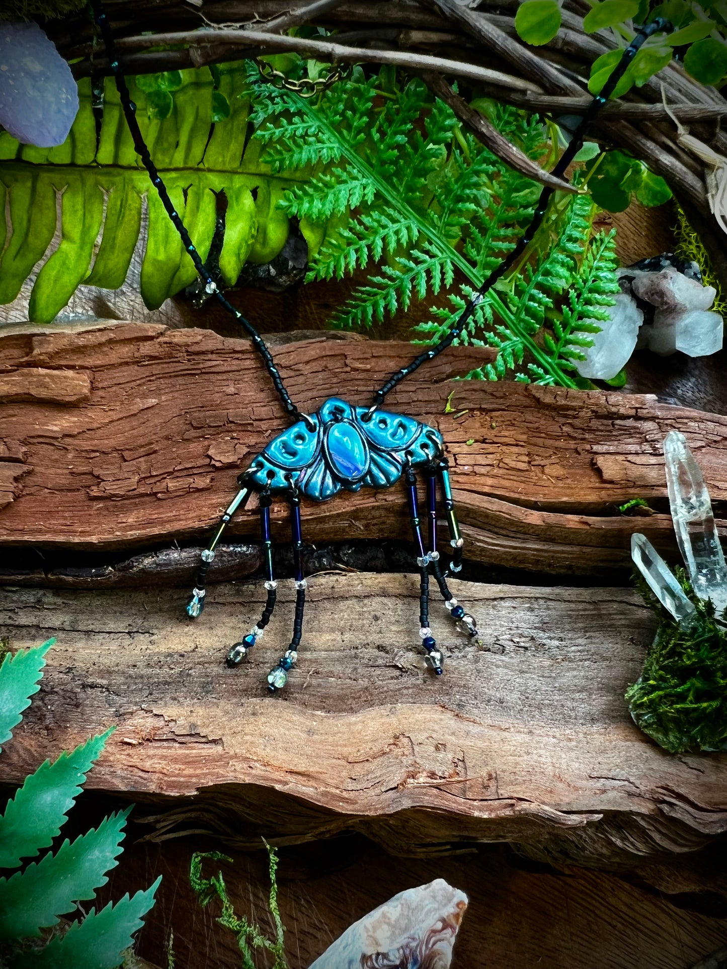 Hand-sculpted polymer clay moth pendant in deep indigo with iridescent details