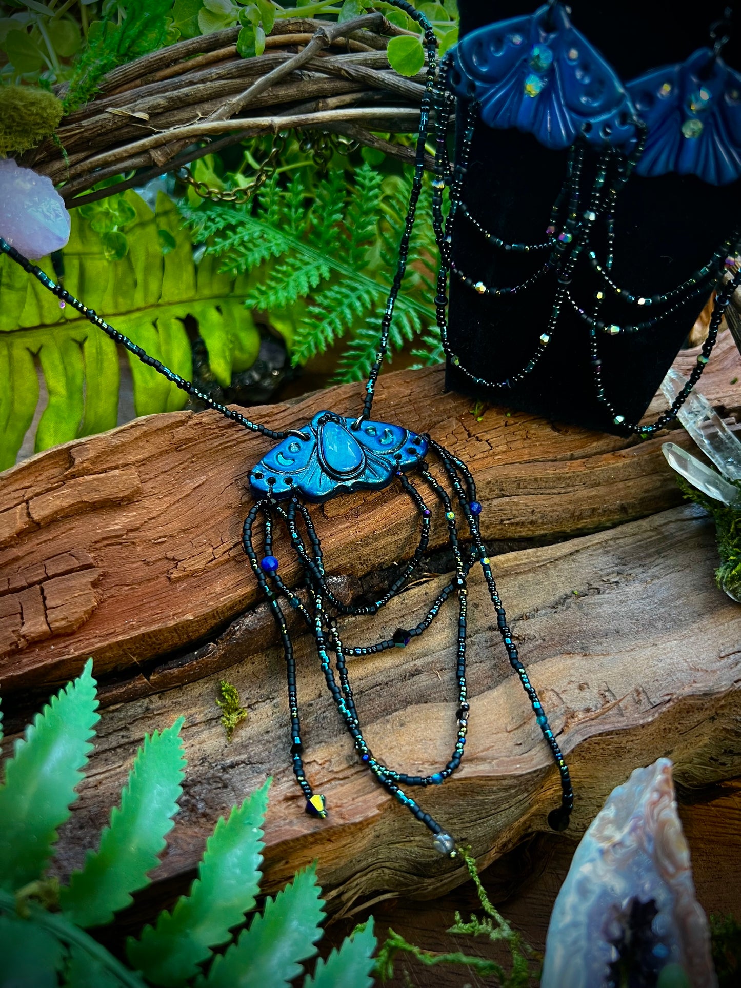 Hand-sculpted polymer clay moth pendant with twilight blue finish and crystal accents