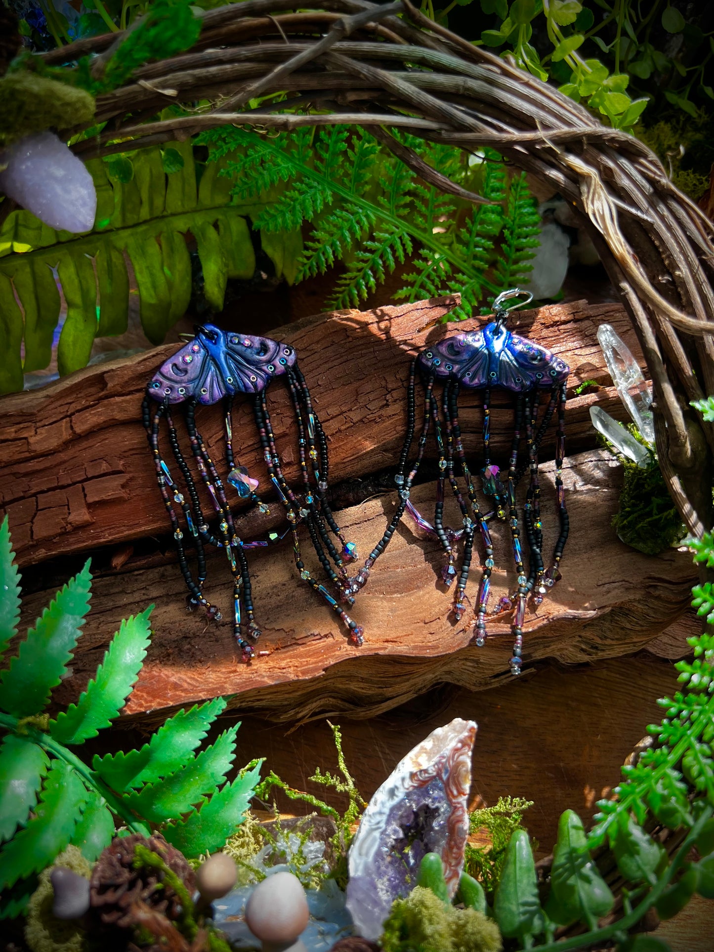 Handcrafted moth earrings with long black seed bead tassels and iridescent crystals