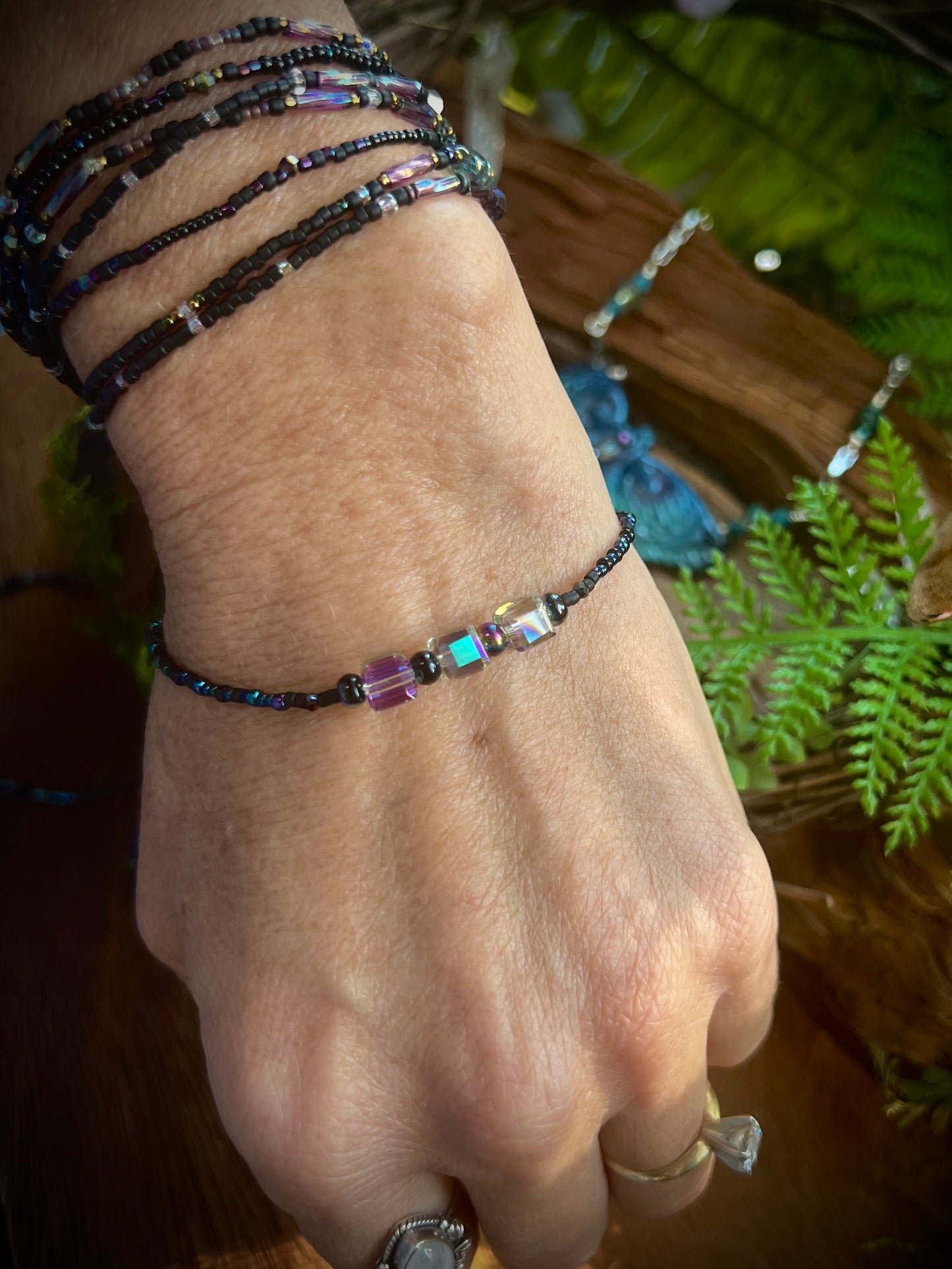 Close-up of aurora stacking bracelets featuring crystals and seed beads