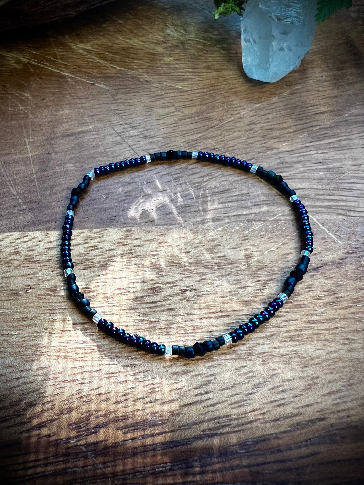 Necklace with blue and black beads on a wooden surface