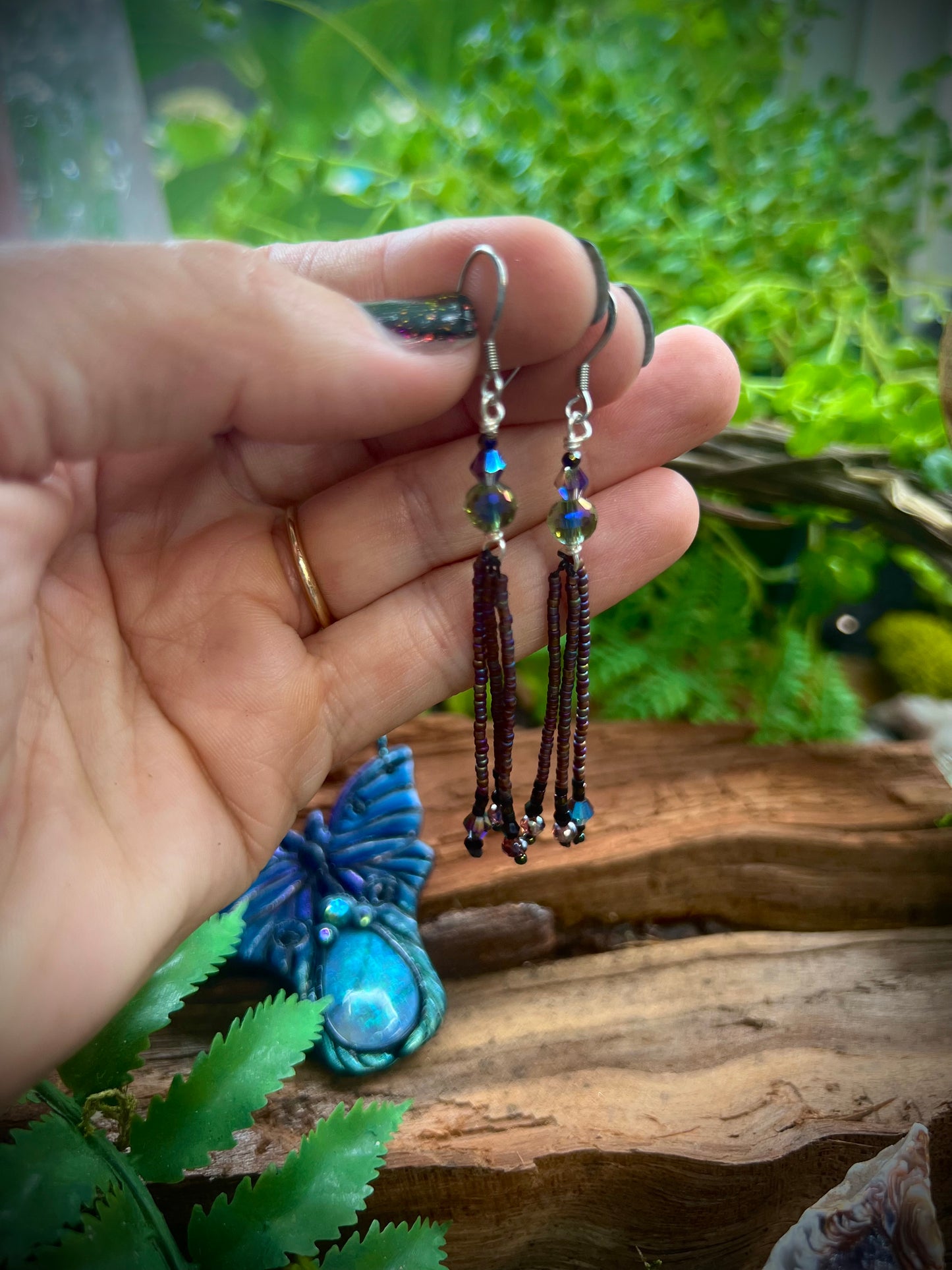 Lightweight mystical fringe earrings displayed against wood and fern leaves