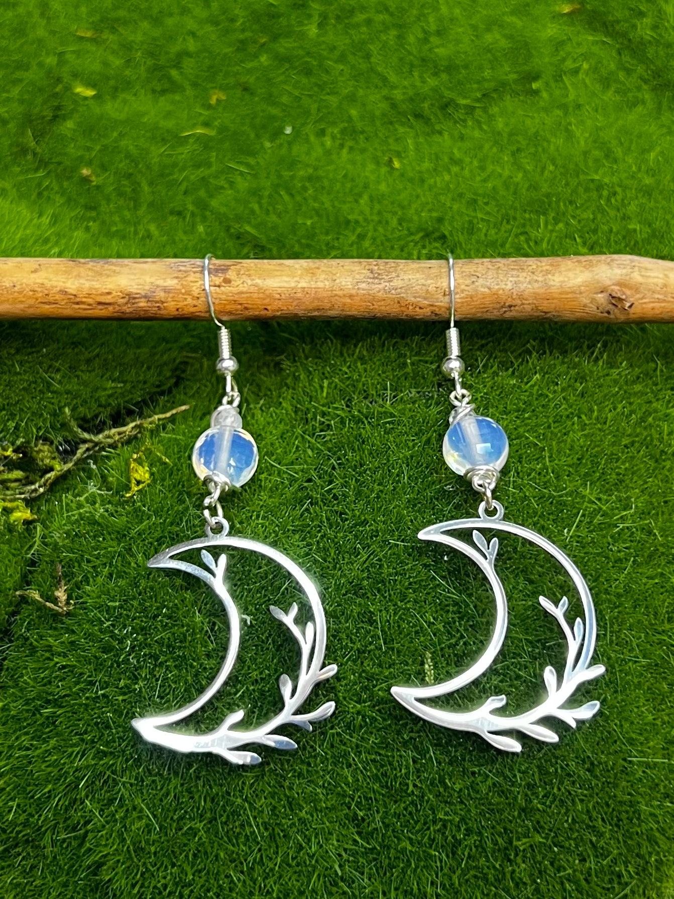 Opalite crescent moon earrings with silver branch design and glowing crystal bead