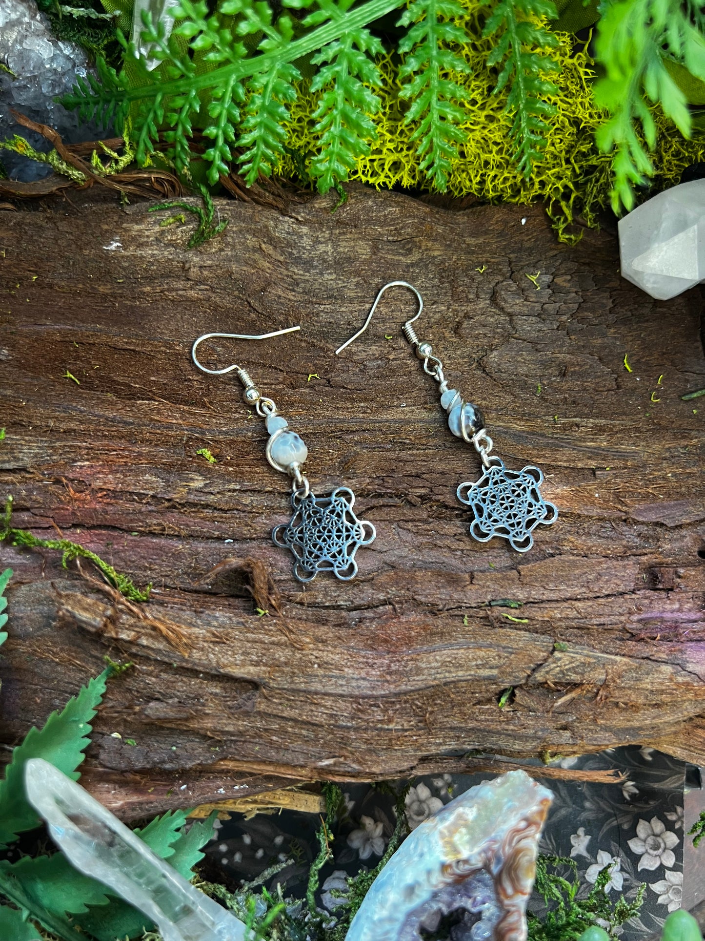 Soothing agate crystal earrings with Metatron’s Cube design in natural forest light