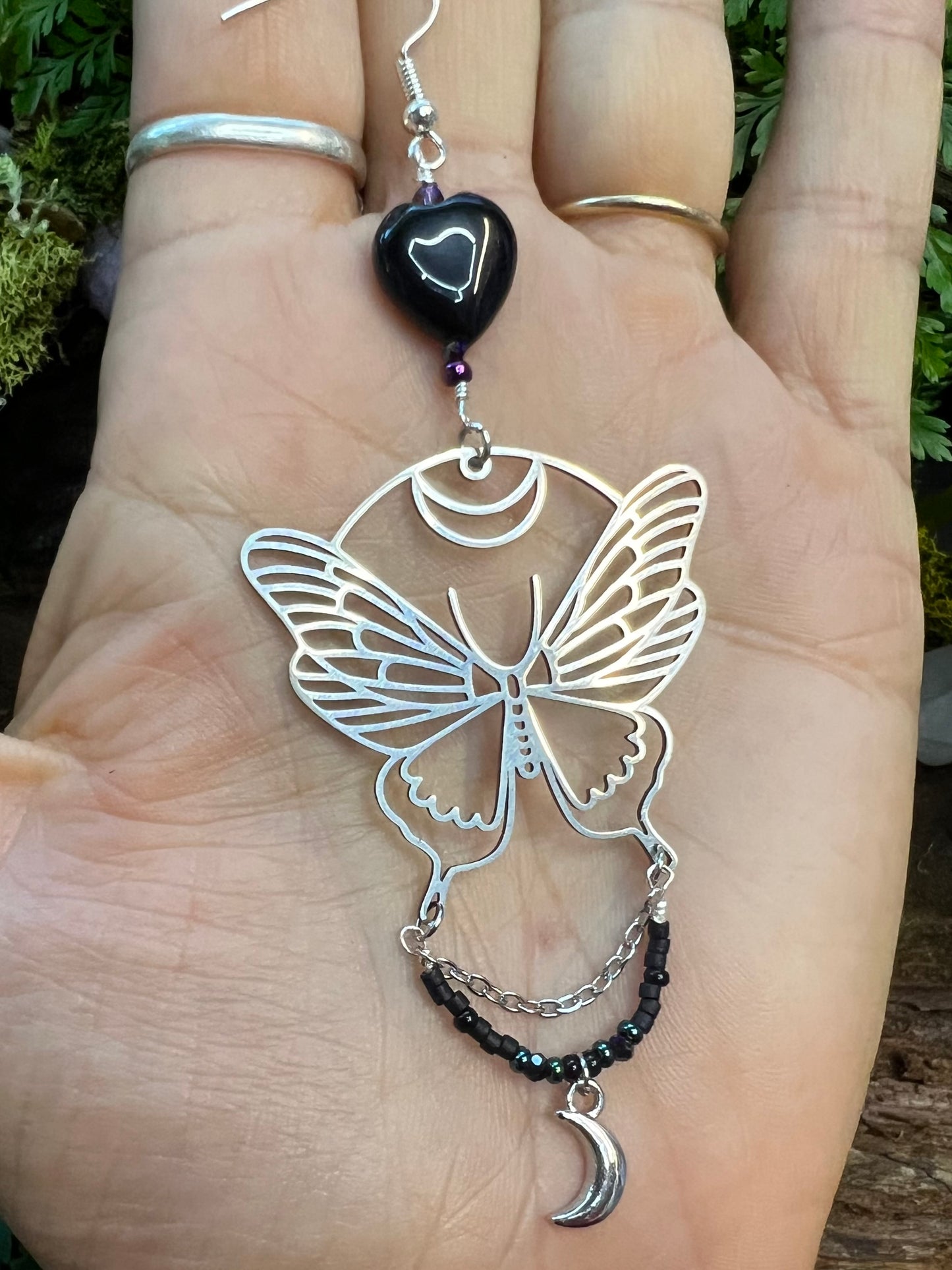 Enchanted black agate earrings featuring moth, moon, and sparkling bead details