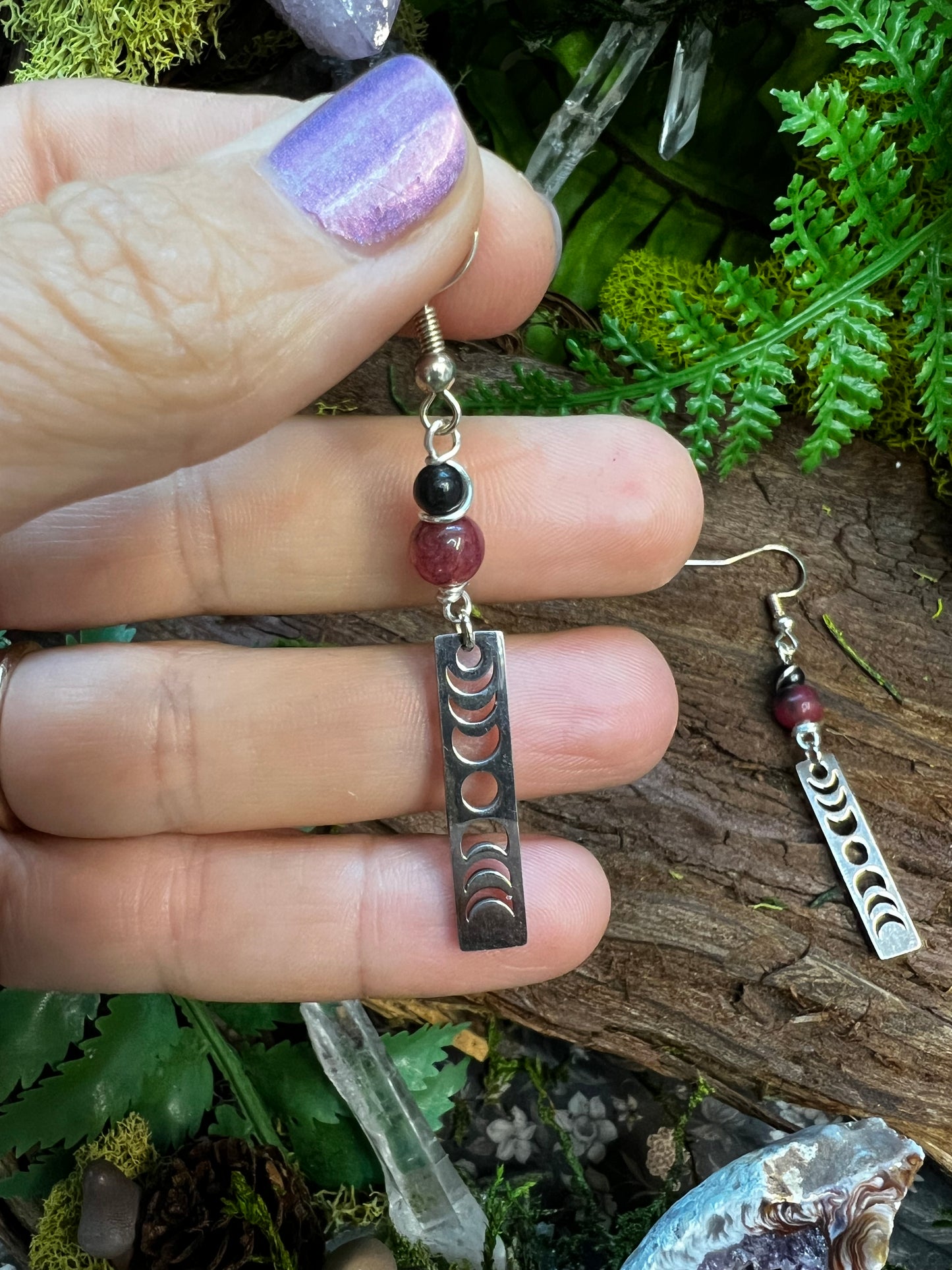 Mystical dyed jade and obsidian earrings with lunar design surrounded by greenery