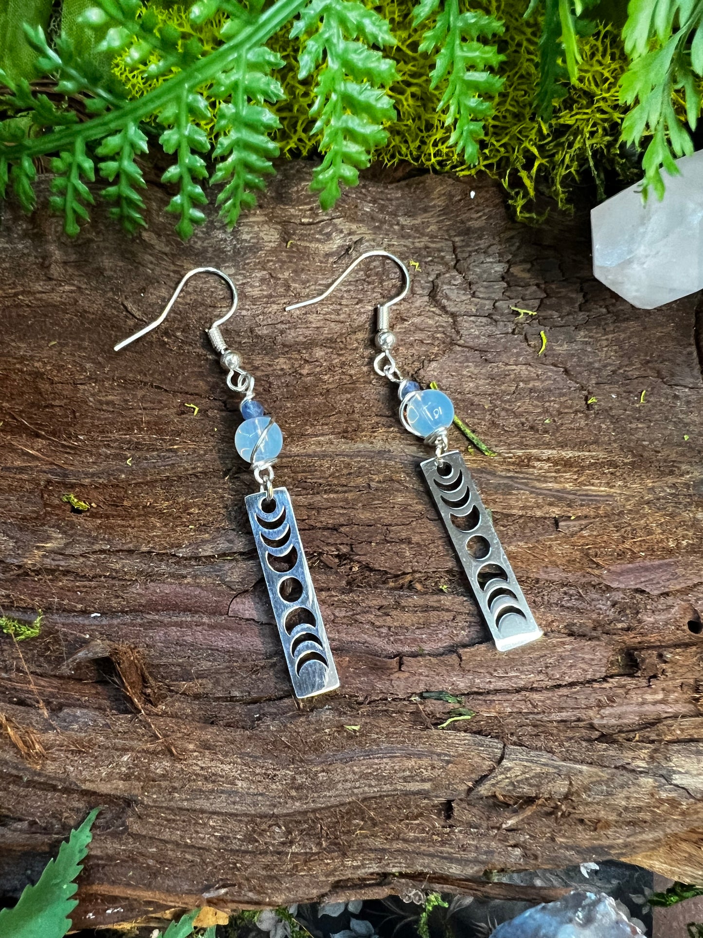 Opalite and kyanite lunar earrings with moon phase charms styled on wood