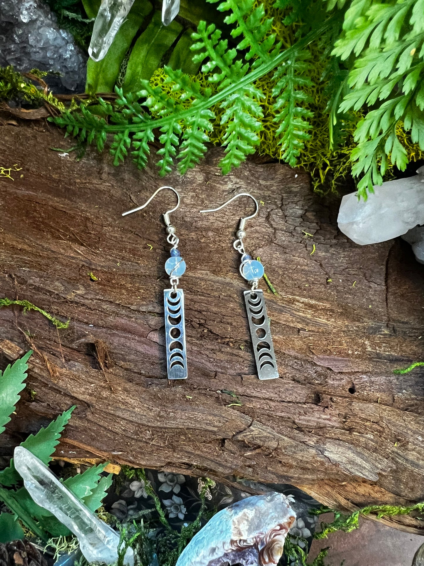 Energy-clearing earrings with opalite and kyanite beads on a natural background