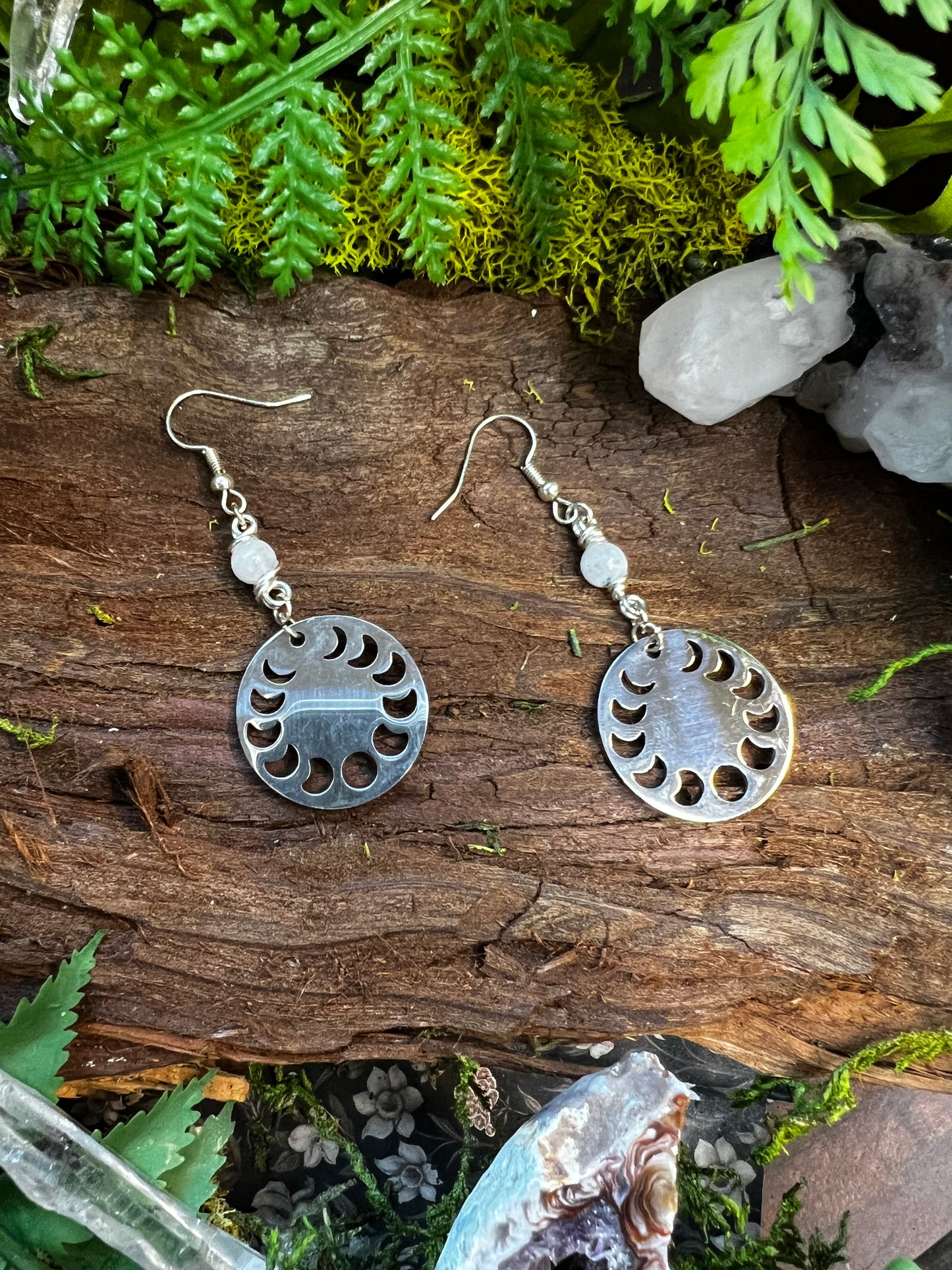 Moon phase earrings with shimmering rainbow moonstone beads styled on a rustic backdrop
