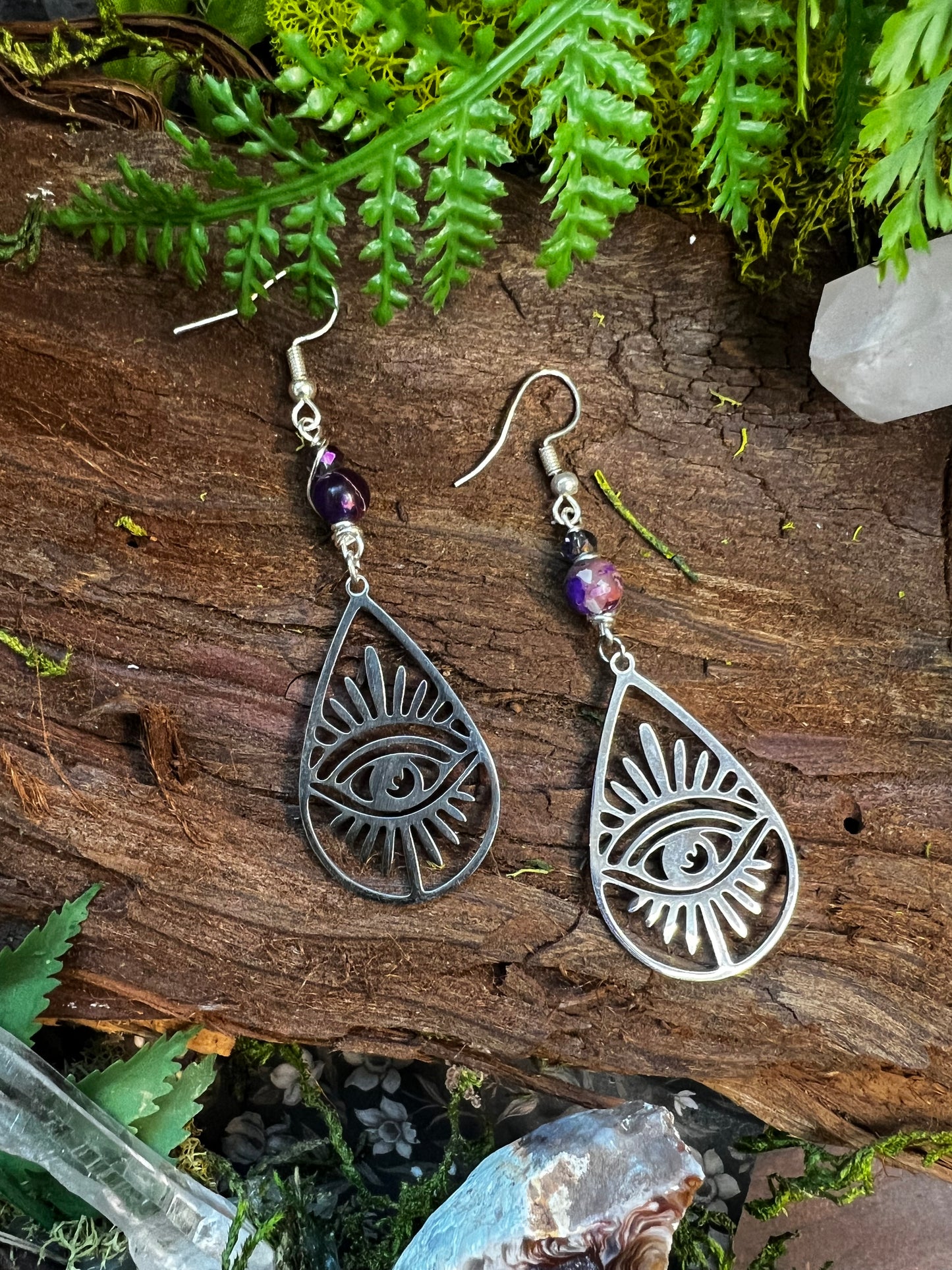 Mystical jasper and quartz earrings featuring protective eye design surrounded by greenery