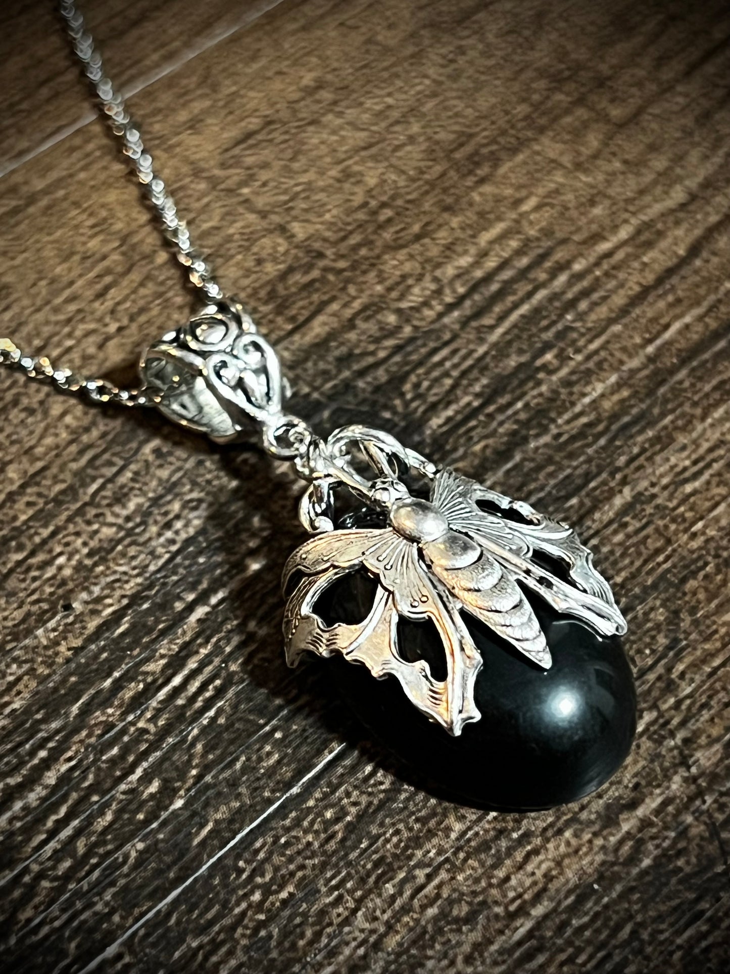 Oval obsidian pendant necklace with antique victorian filigree moth wrap