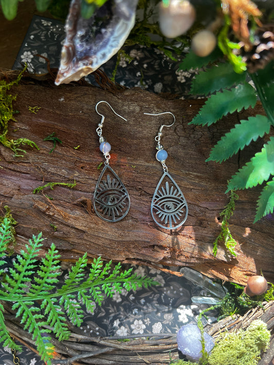 Close-up of celestial earrings featuring angelite and spiritual protection motifs
