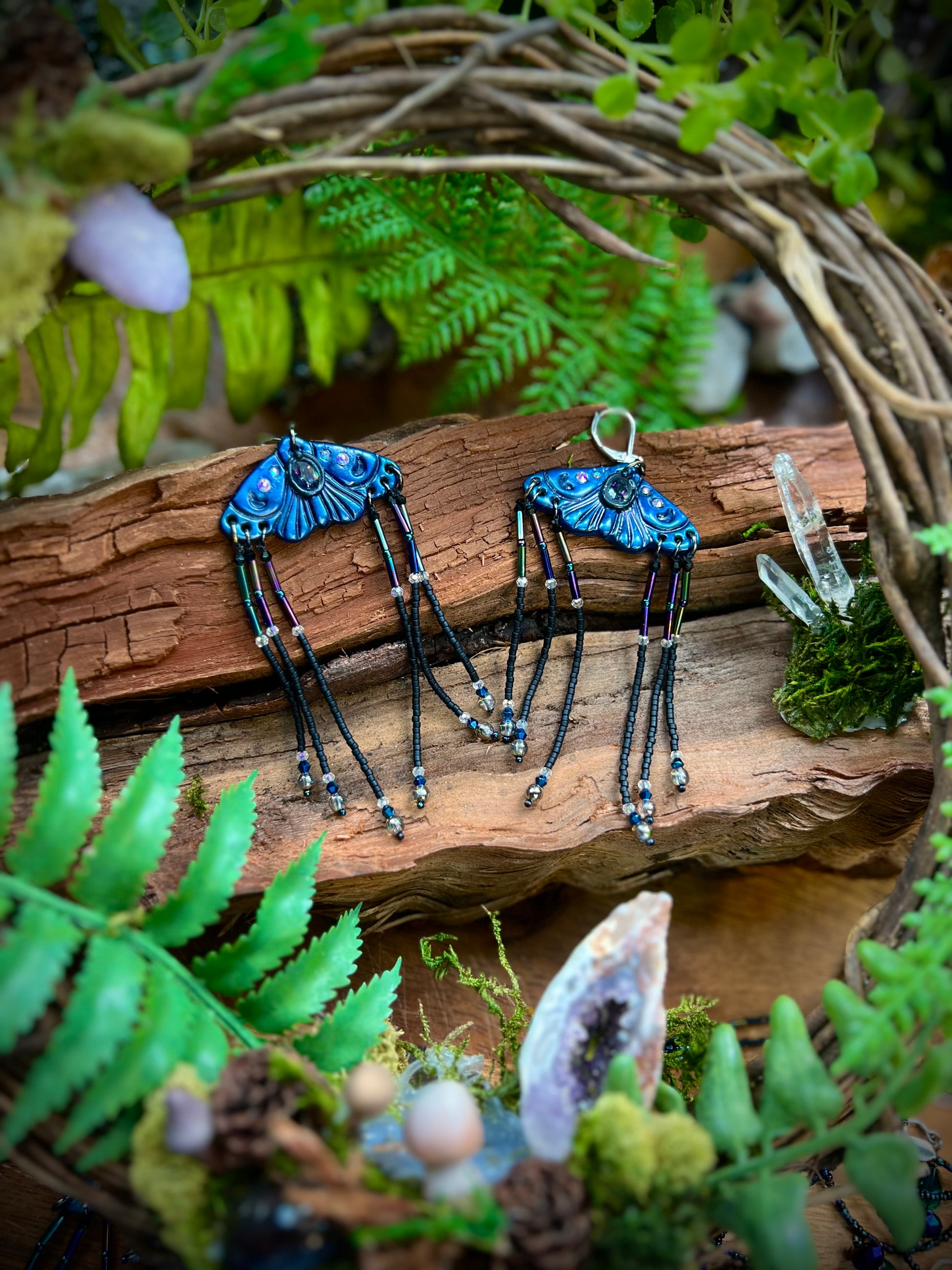 Hand-sculpted blue moth earrings with mystical crystal centerpiece