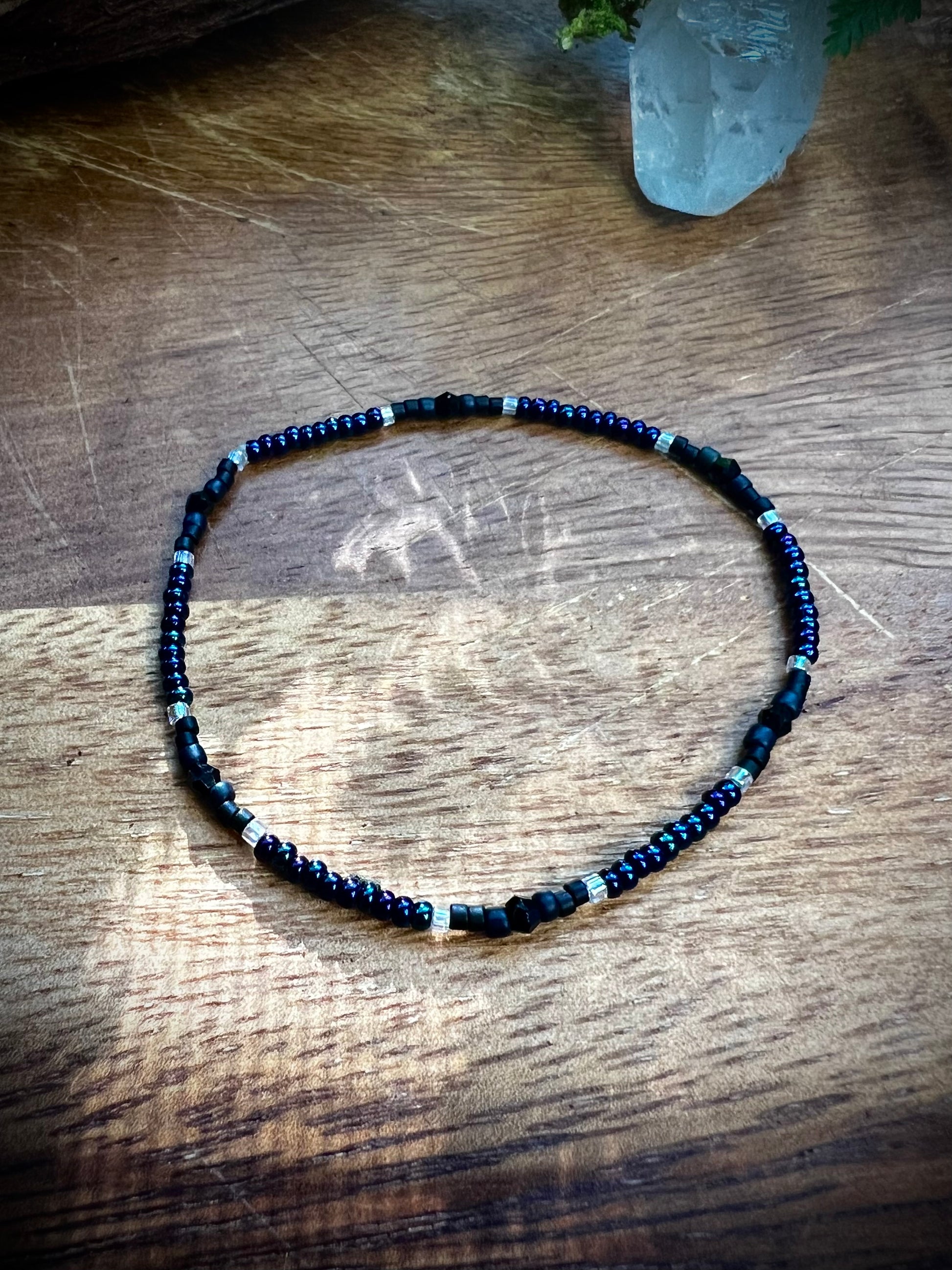 Necklace with blue and black beads on a wooden surface
