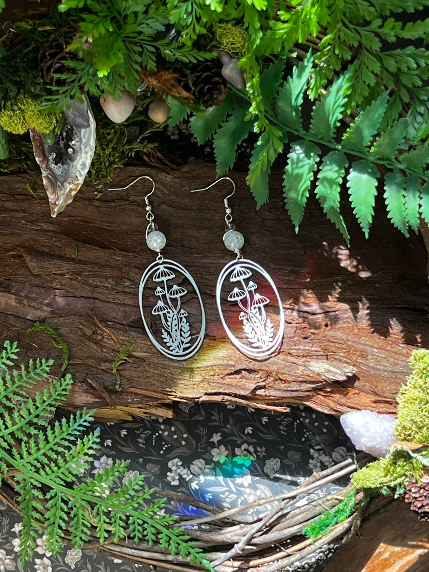 Handmade earrings with etched mushroom designs and shimmering aura crackle quartz accents