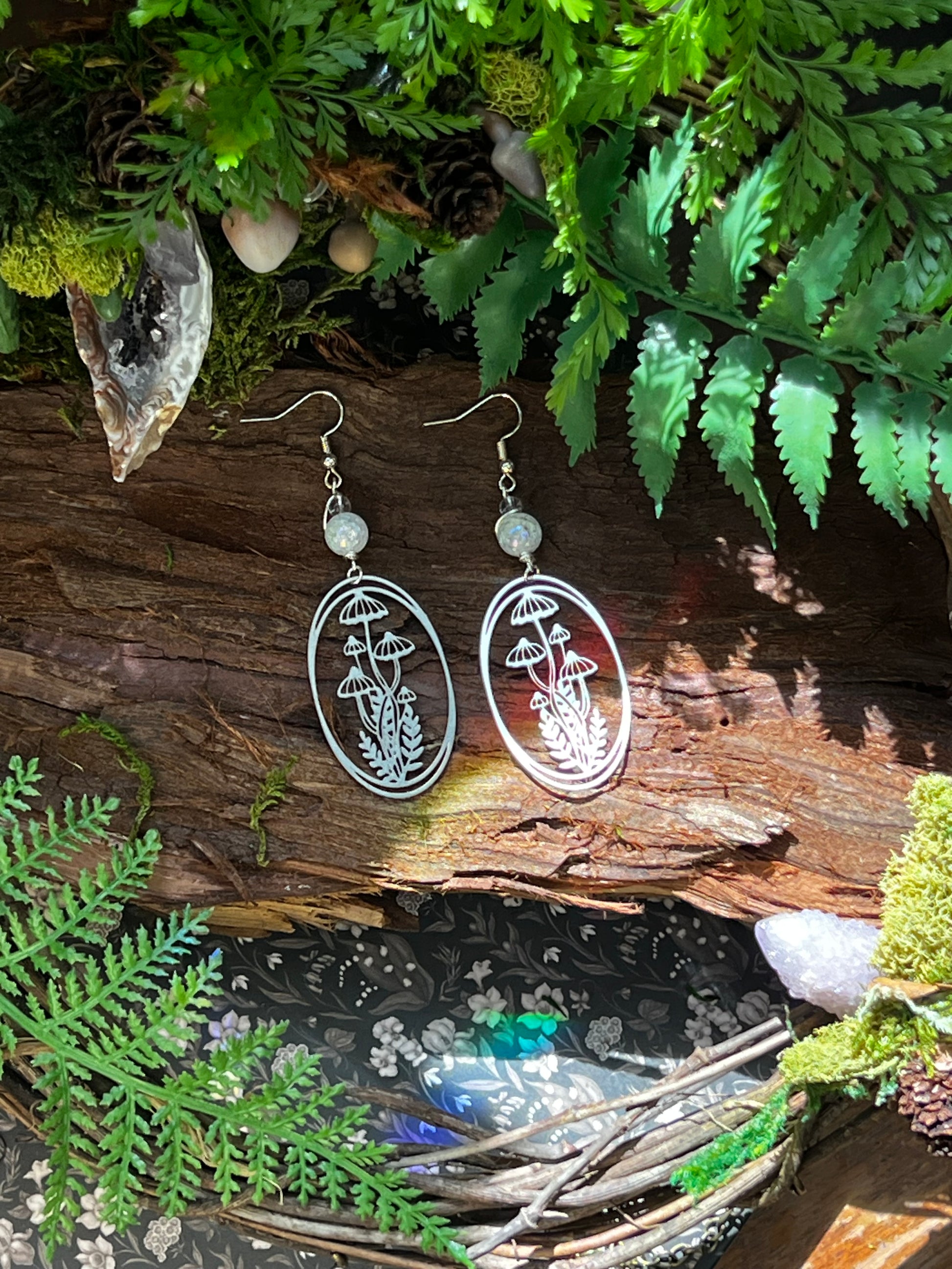 Handmade earrings with etched mushroom designs and shimmering aura crackle quartz accents