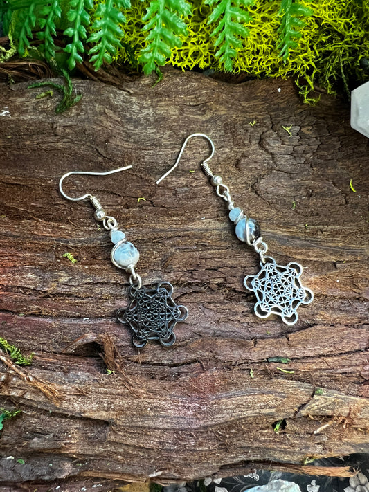 Grounding agate Metatron earrings with sacred geometry charms styled on moss and wood