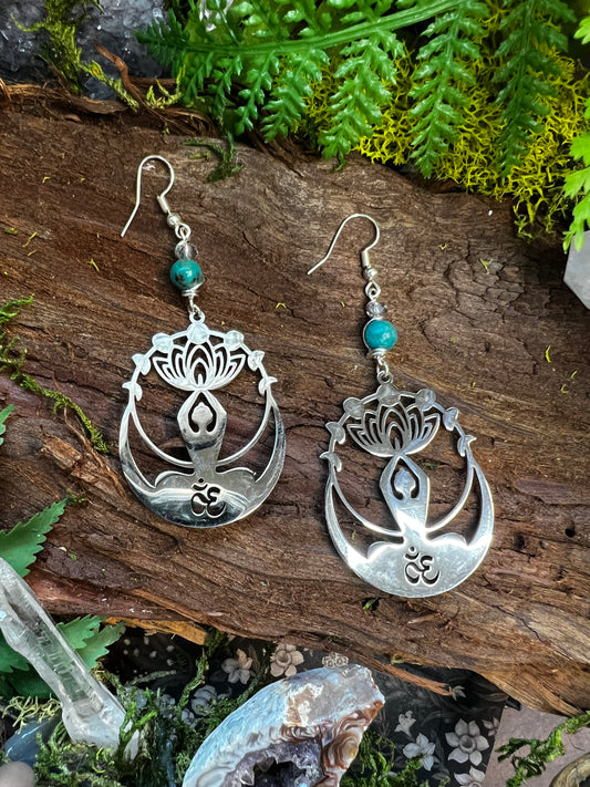 Chrysocolla and iridescent quartz Om earrings with lotus charms styled on moss and wood