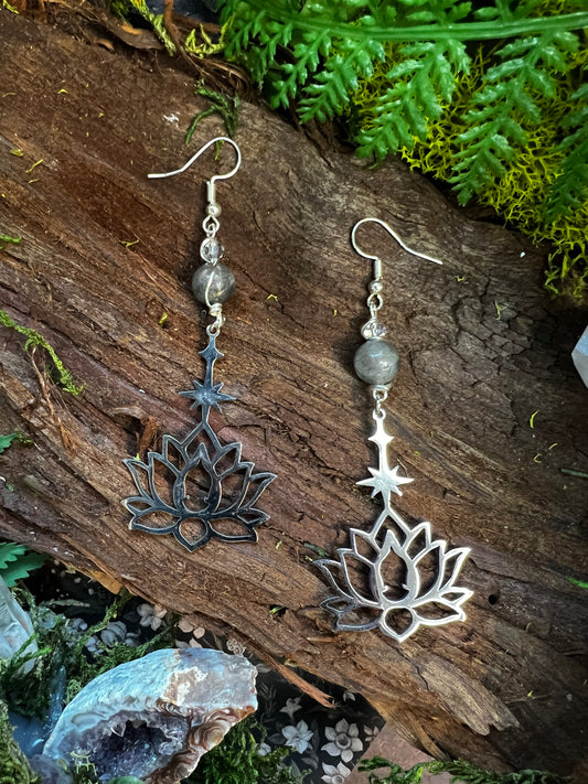 Labradorite and quartz lotus earrings with star charms styled on moss and wood