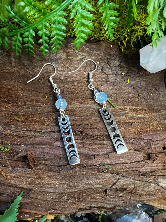 Opalite and kyanite lunar earrings with moon phase charms styled on wood