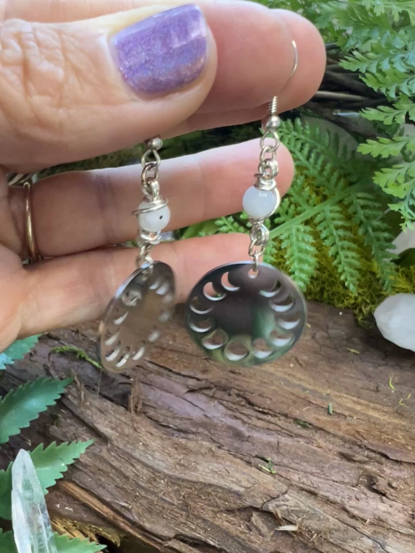Emotional balance earrings with moon charms and rainbow moonstone on wood