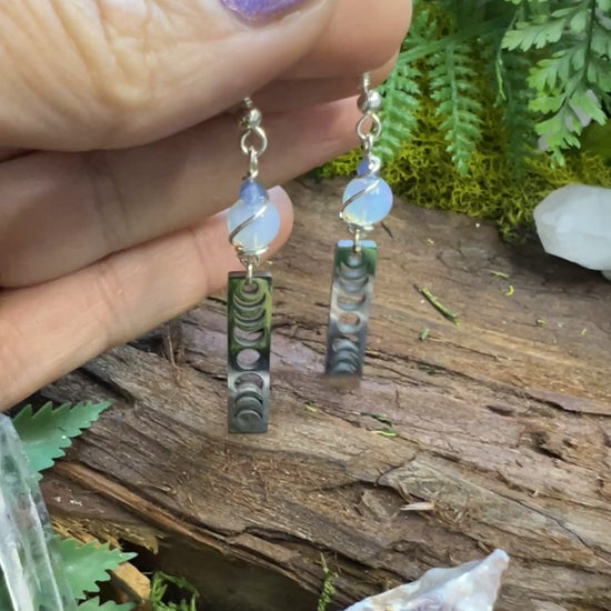 Lunar energy alignment earrings with opalite and kyanite surrounded by moss
