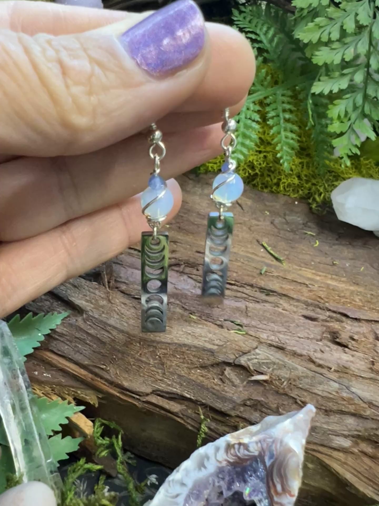 Lunar energy alignment earrings with opalite and kyanite surrounded by moss
