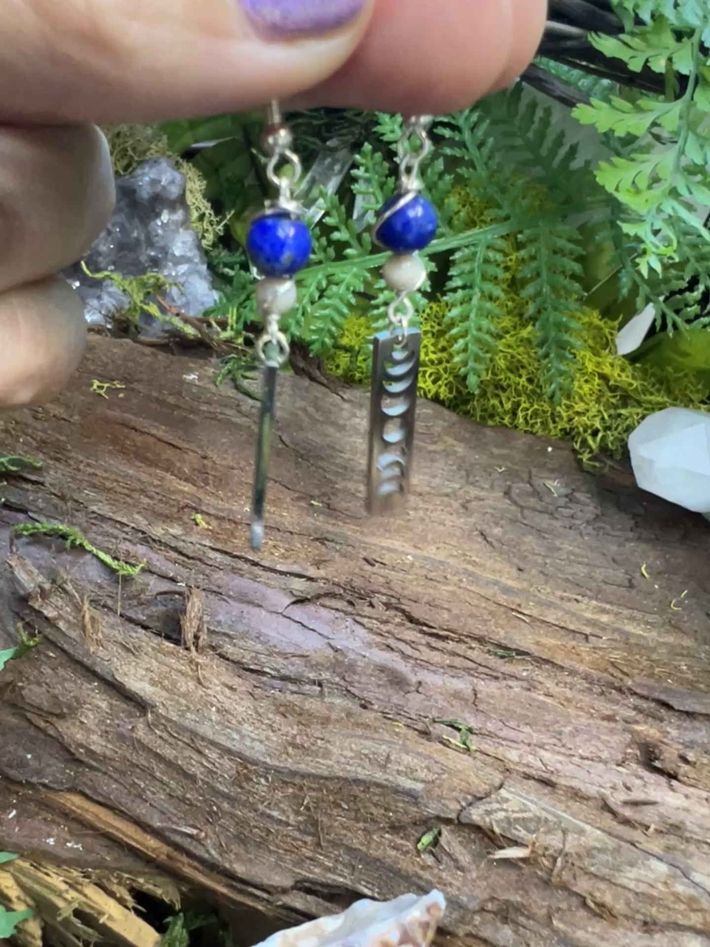 Lunar cycle earrings with healing crystals resting on forest textures