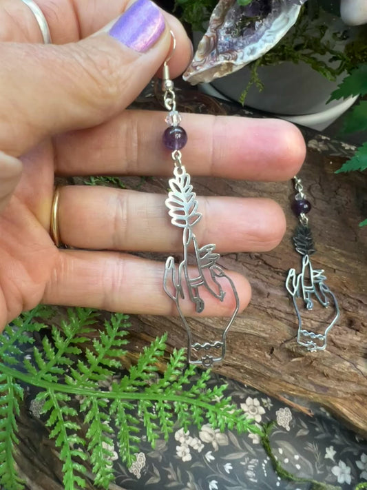 Amethyst and quartz earrings with botanical hand charms and forest-inspired styling