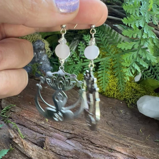 Spiritual rose quartz and clear quartz earrings surrounded by moss and natural textures
