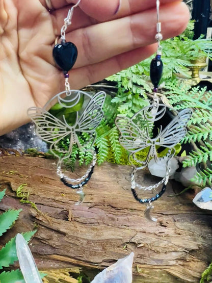 Magical transformation earrings with black agate and moon phases resting on rustic background