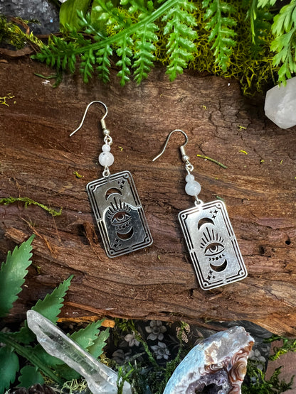 Spiritual tarot earrings with rainbow moonstone beads resting on rustic natural background