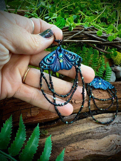 Close-up of crystal accents on woodland moth earrings glowing in light